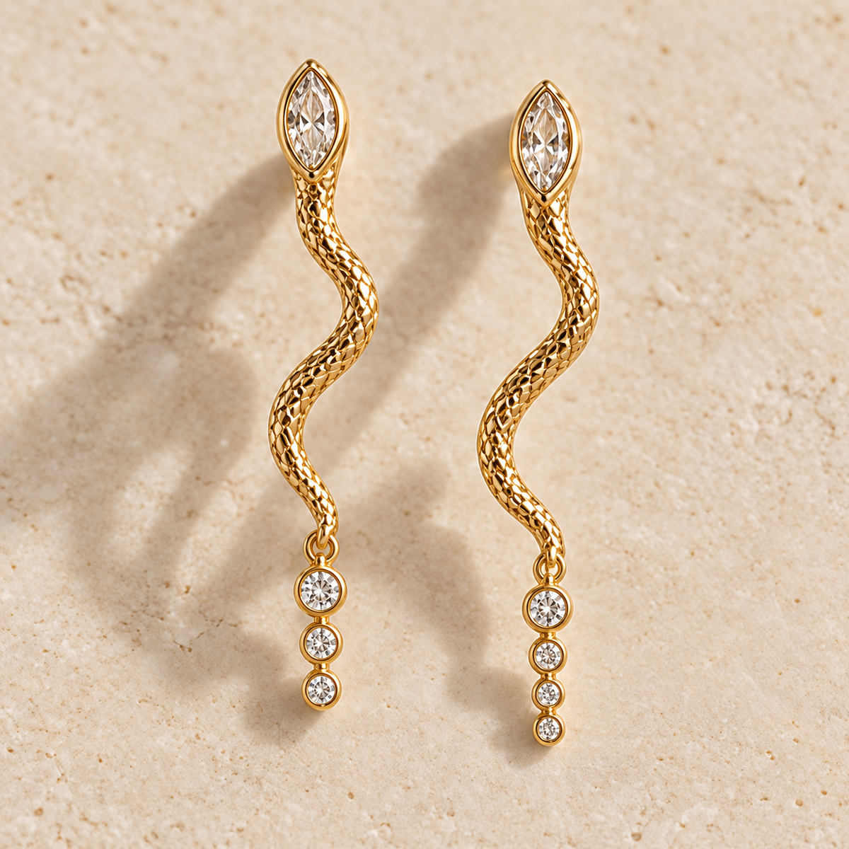 Apsara Trinity Serpent Earrings, matching gold-finished snake drops with marquise and three round clear crystals